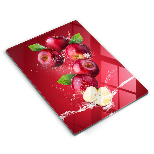 Chopping board glass Juicy apples in the water