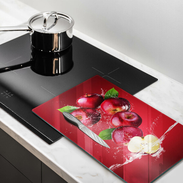 Chopping board glass Juicy apples in the water