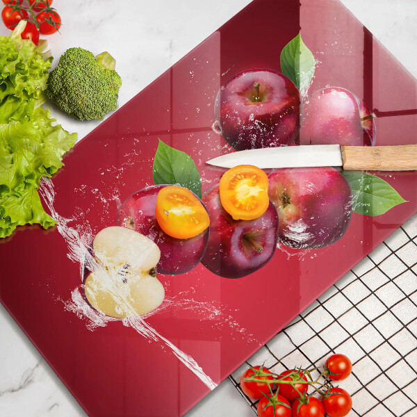 Chopping board glass Juicy apples in the water