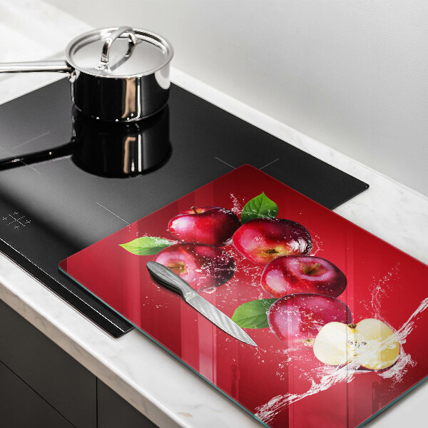 Chopping board glass Juicy apples in the water