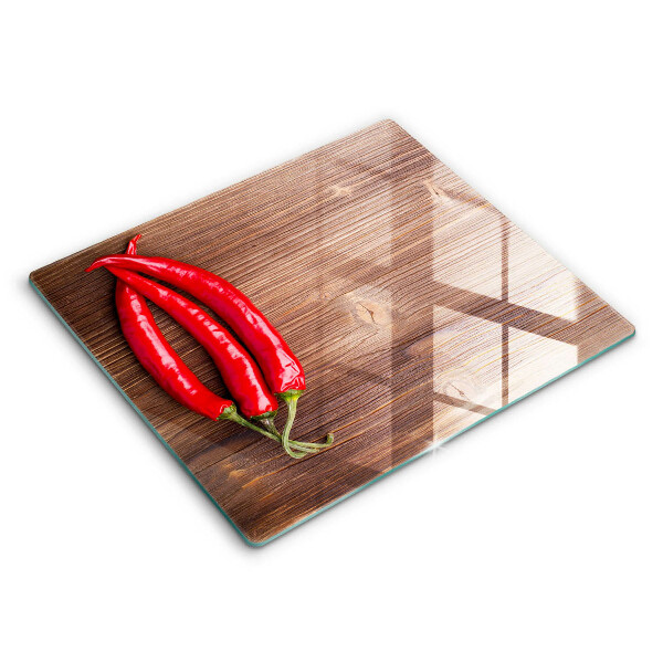 Chopping board glass Chili peppers on wood