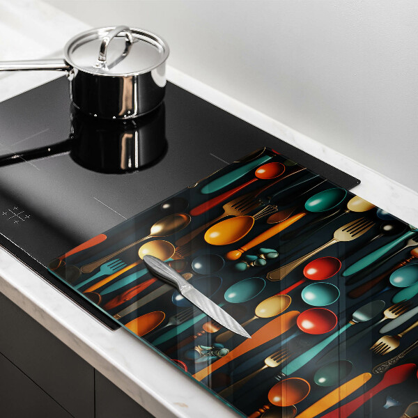 Chopping board glass Colorful spoons and forks