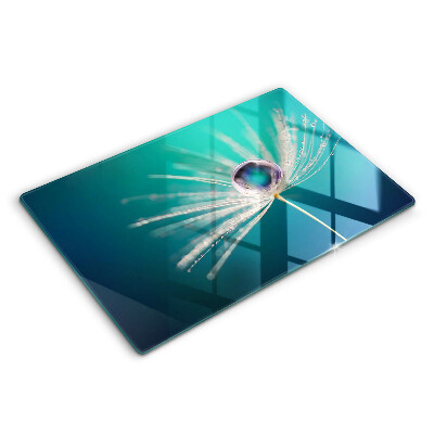 Chopping board glass Dew on a dandelion
